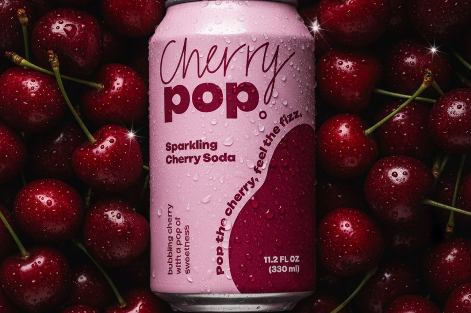 Cherry Pop sparkling cherry soda can resting on a bed of fresh dark cherries