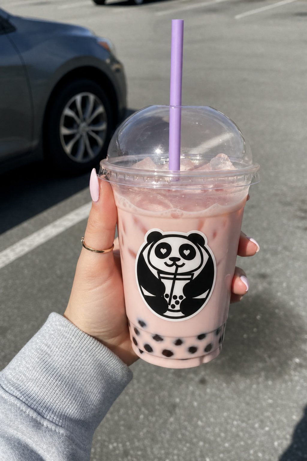 Poba Boba strawberry milk tea with tapioca pearls held in one hand